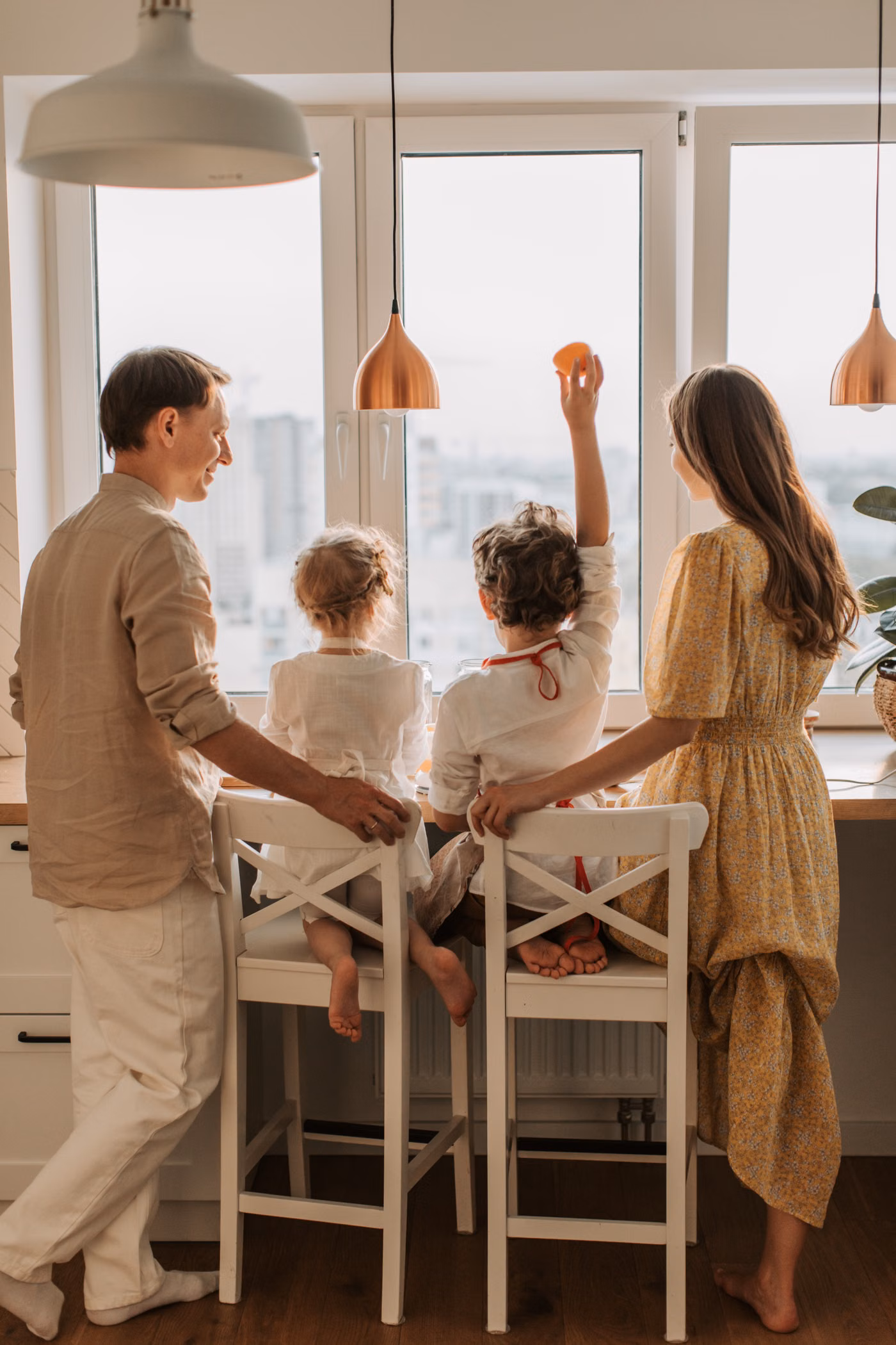 Parents and two children sharing time together in a bright kitchen