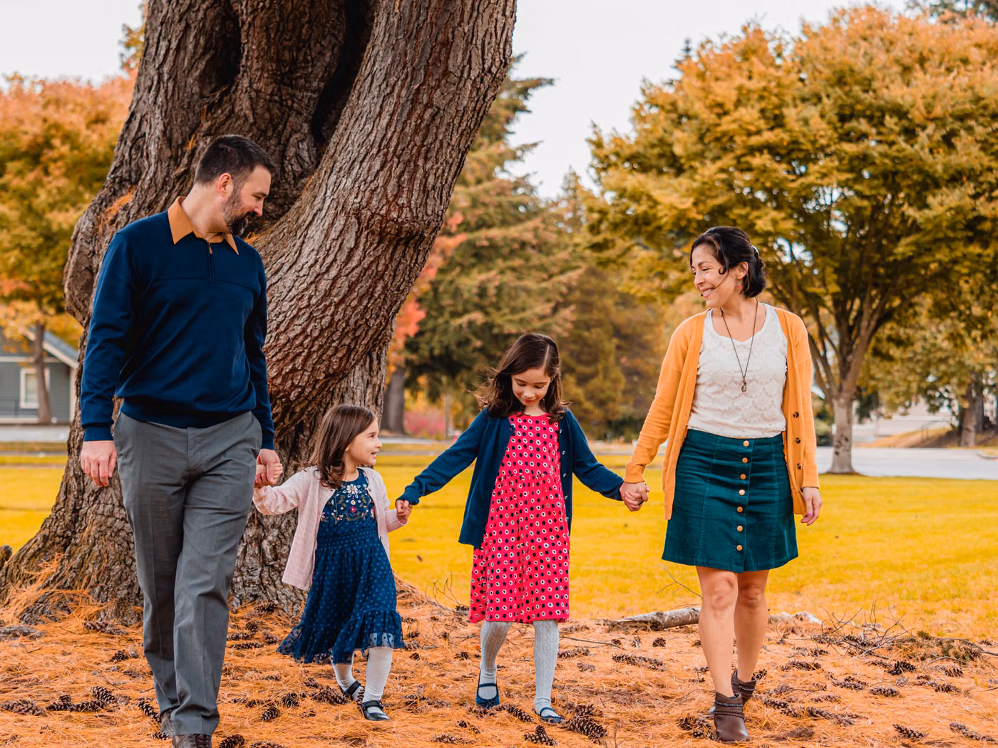 Parents and two children walking together through an autumn park